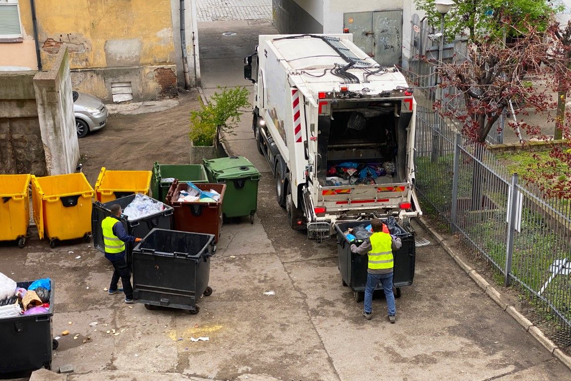 Crew loading bins into a hauling truck at a residential property